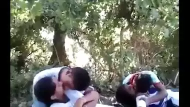 College couples enjoying outdoor kissing infront of their friends